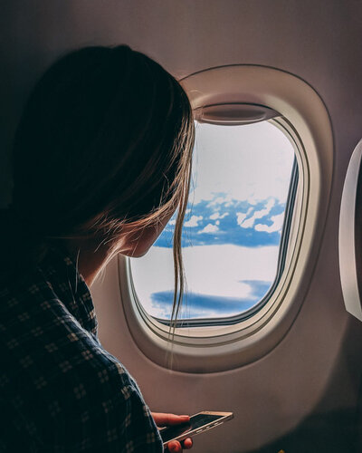 In the plane A woman by the window inside a plane