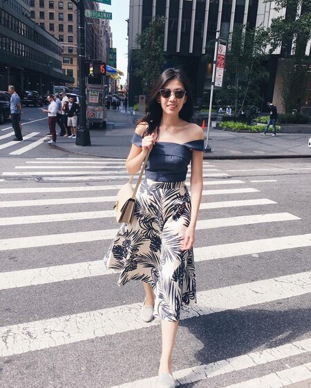 Raena Lim Girl wearing palm leaves-printed skirt crosses the street