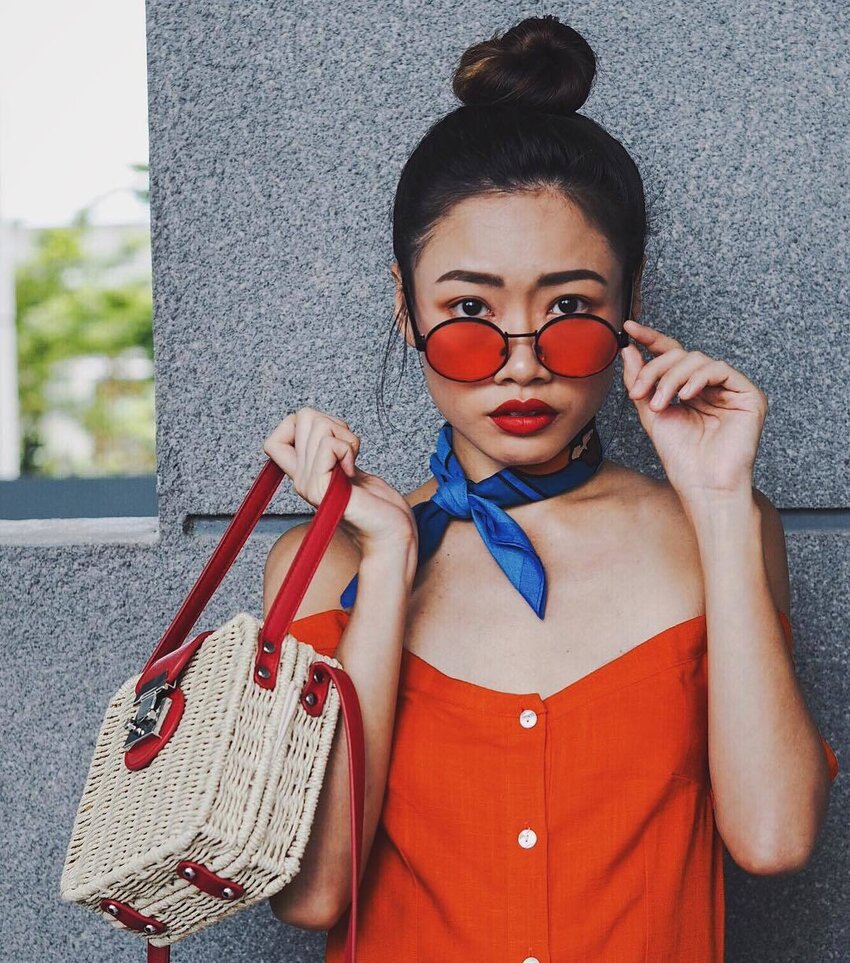 Sunset-coloured sunnies Woman wearing a round frame orange tinted sunglasses