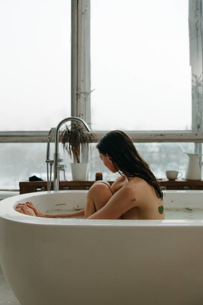 Woman sitting on bathtub