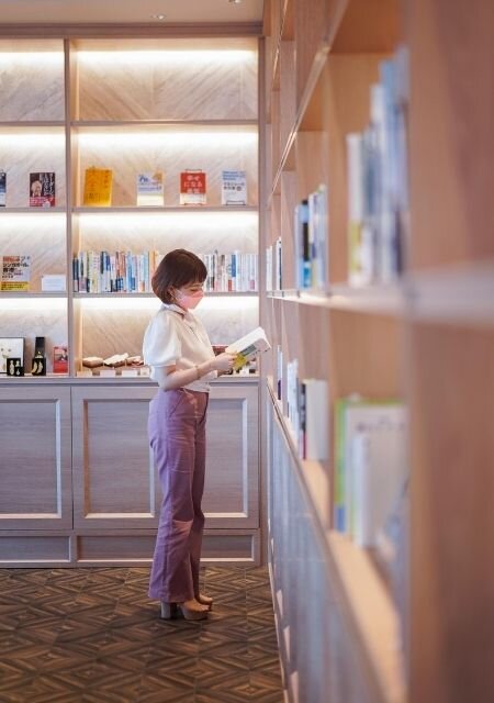 woman reading books from shelf