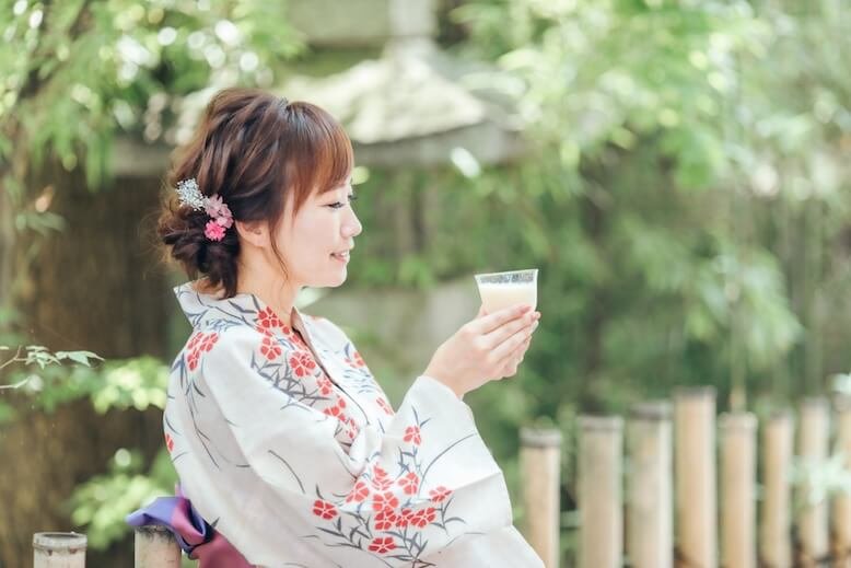Japanese woman in kimono drinking Amazake