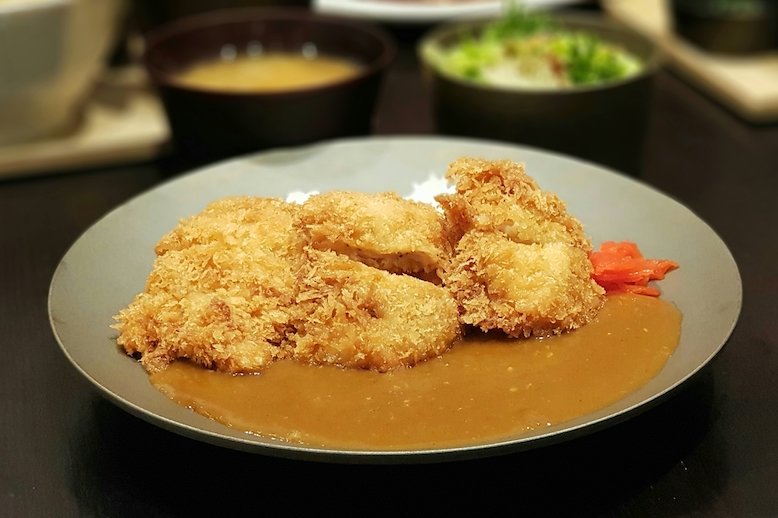 Breaded chicken sitting on a bed of curry