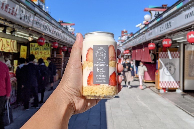 Hand holding parfait in can in busy street