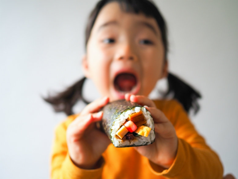 Girl eating eho-maki for Setsubun in Japan
