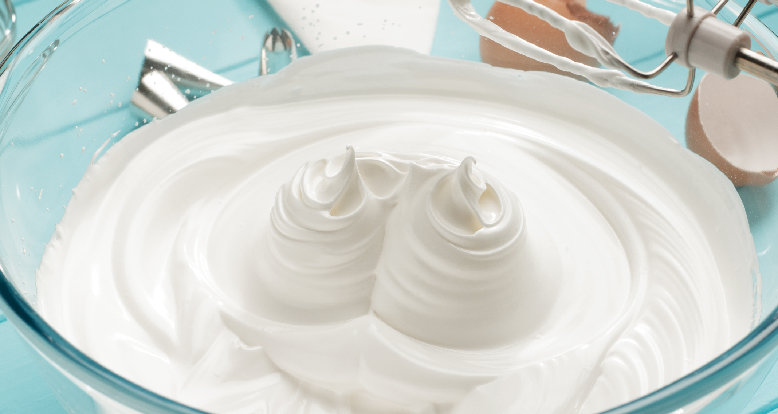A bowl of creamy Japanese pancake batter, with two twirls standing stiff like a merengue