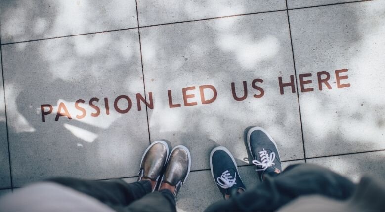 New opportunities Two people standing on sign saying 'passion led us here'