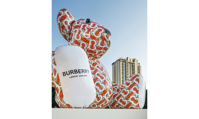 A giant inflatable Burberry bear bears the brand's new logo on its right foot and the new monogram all over its body.