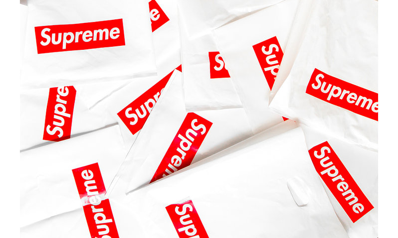 A pile of numerous white plastic bags with the supreme logo.