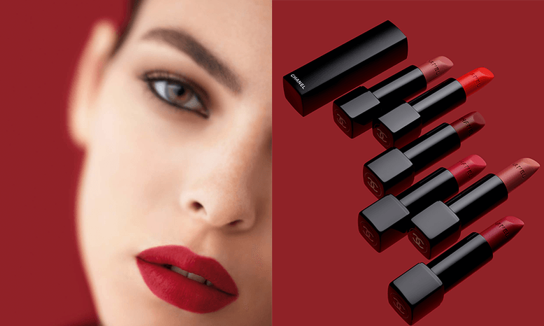 A woman wearing a red lipstick and a variety of lipsticks in black casing all lined up